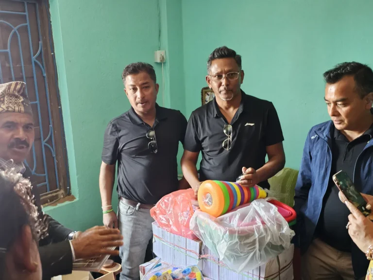 विद्यालयको कार्यालयमा कक्षाका सामग्रीसहित उभिएका AAAK सदस्य