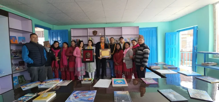 Projects पुस्तक दराजसहितको नयाँ पुस्तकालय कक्षमा प्रमाणपत्र लिएर उभिएका AAAK सदस्य, शिक्षक र अतिथि