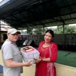 कापीको बन्डल सँगै समातेर मुस्कुराउँदै सचिव राम पण्डित र शिक्षिका