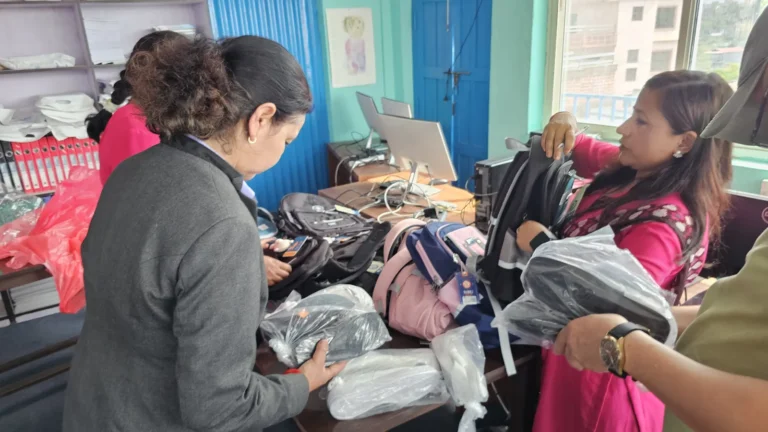विद्यालयको कार्यालयमा टेबलमा झोला र जुत्ता मिलाउँदै महिलाहरू