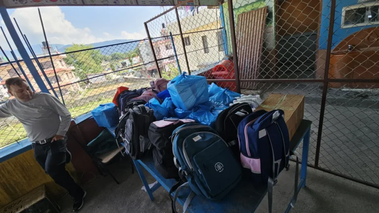 टेबलमा राखिएका विद्यालय झोला र निलो झोलामा सामग्री