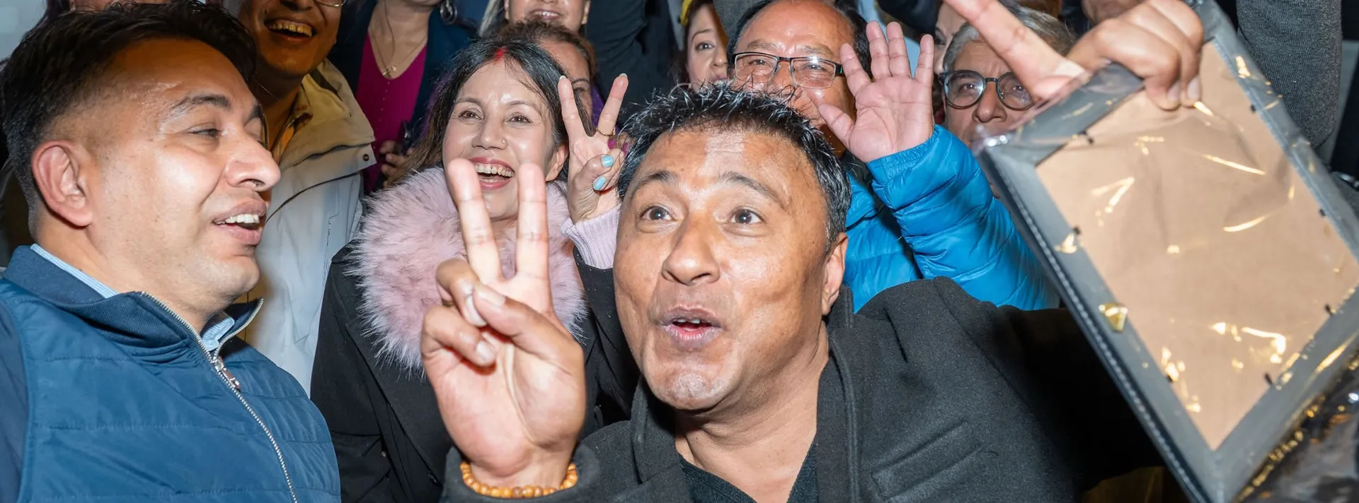 Alumni celebrating with victory signs at an AAAK gathering