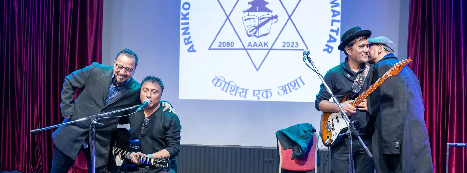 Alumni musicians performing in front of the AAAK emblem