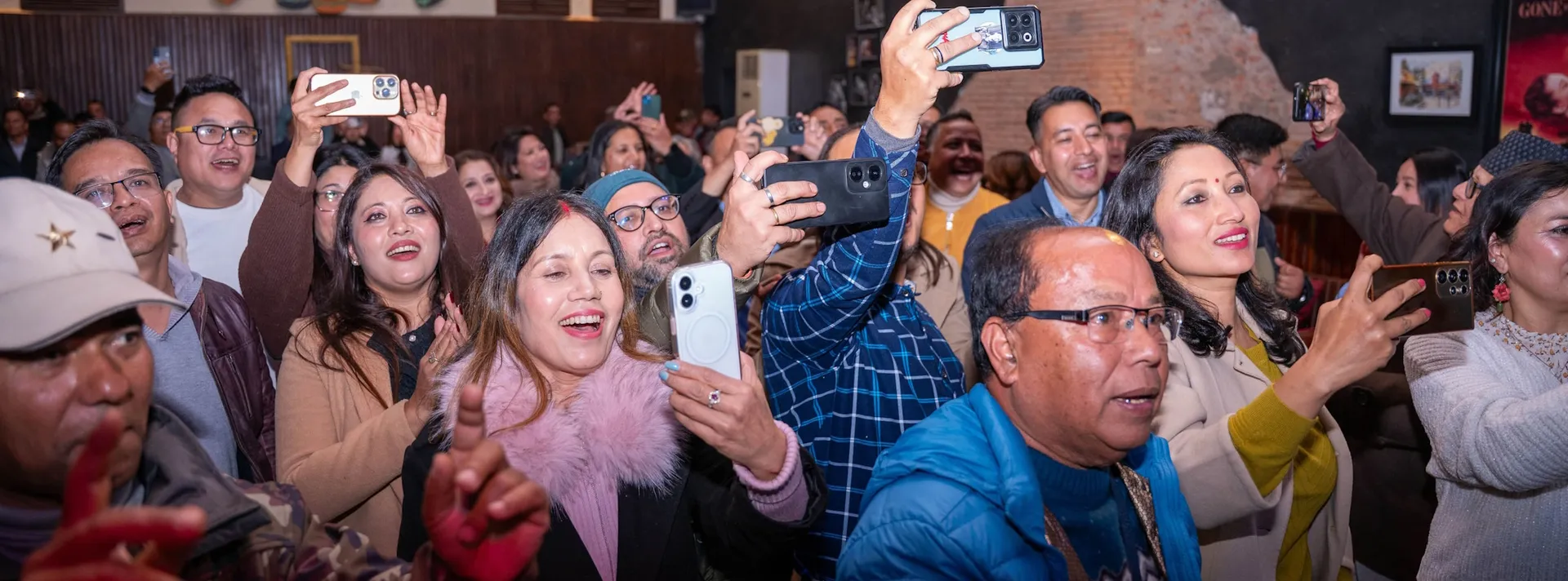 Alumni cheering and filming a performance at an AAAK gathering