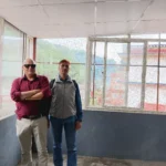 नयाँ झ्याल र सेतो सिलिङ भएको उज्यालो हलमा उभिएका दुई जना