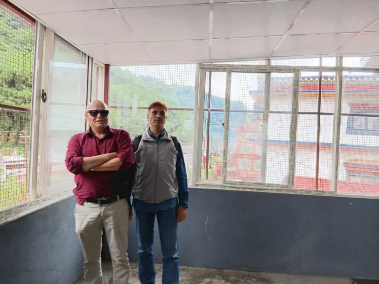 नयाँ झ्याल र सेतो सिलिङ भएको उज्यालो हलमा उभिएका दुई जना